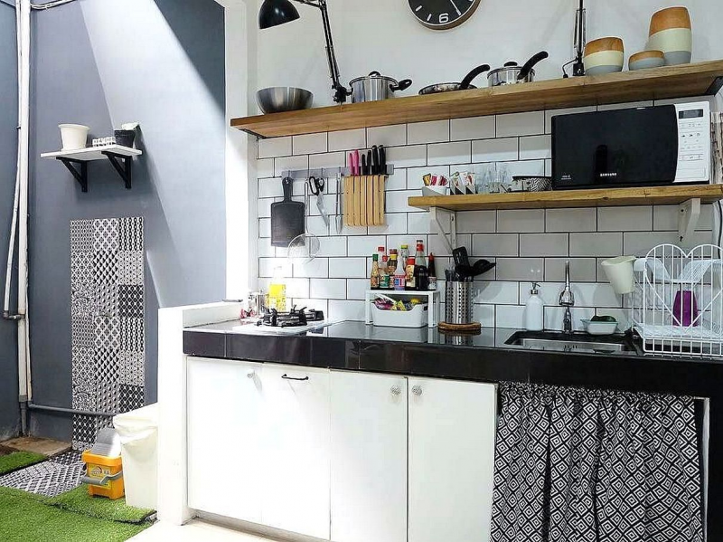 Agar dapur terlihat lebih luas, ganti lemari tertutup pada bagian atas dengan rak kayu sebagai tempat untuk menaruh peralatan memasak. Dan juga tambahkan gantungan rak kayu untuk tempat pisau
