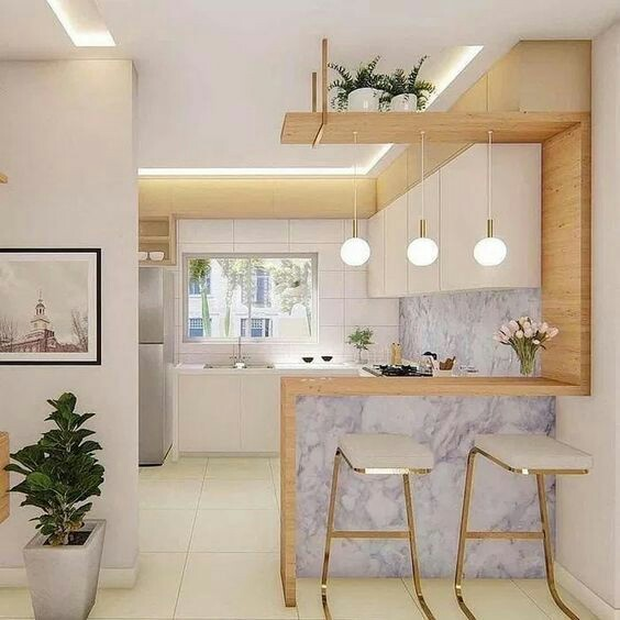 Dominasi warna putih yang sleek terlihat jelas dari model dapur di bawah ini. Namun untuk menghindari dapur terlihat membosankan, anda bisa menggabungkan aksen kayu dengan batu marmer yang cantik dan kursi berangka emas