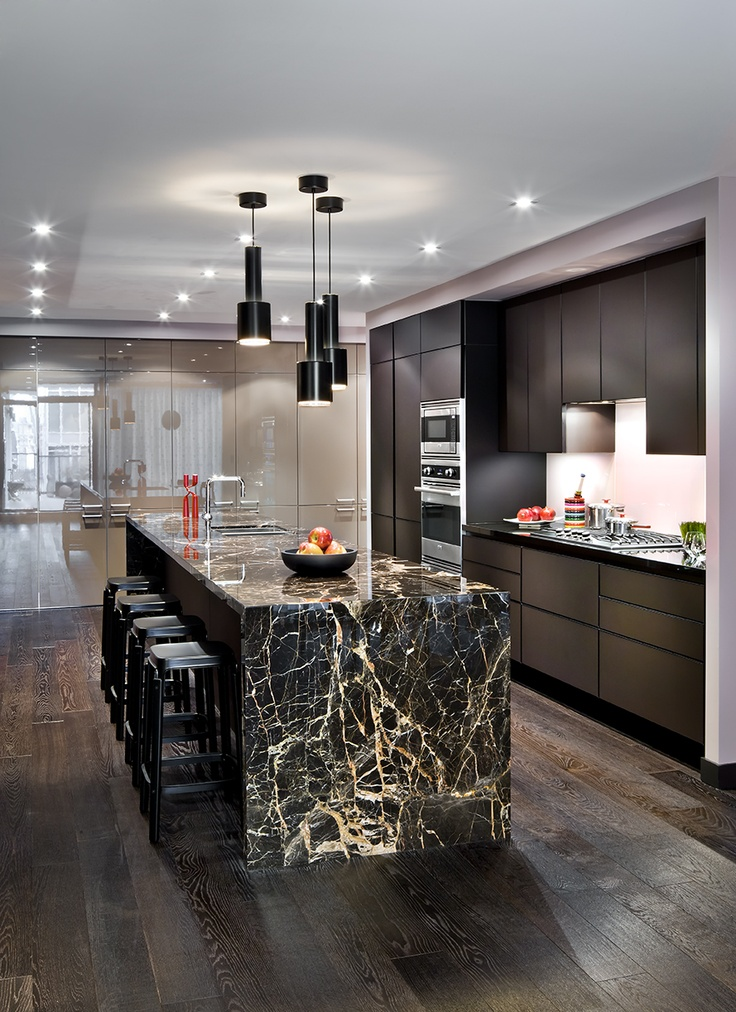 Dengan dominasi warna hitam yang natural terlihat dari kitchen set dan lampu gantung modern yang cantik, anda bisa menambahkan meja tebal dari material marmer untuk kesan mewah