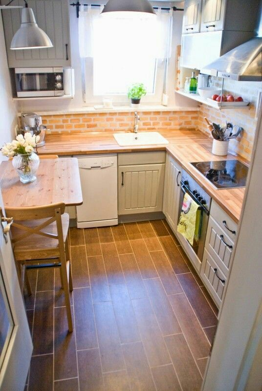 Contoh dapur kecil yang satu ini pas untuk anda yang tinggal sendiri. Berikan kesan hangat dengan pemilihan warna cokelat atau beige. Untuk mempercantik, anda dapat menambahkan aksen batu bata pada dinding dan meja makan kecil dengan satu kursi