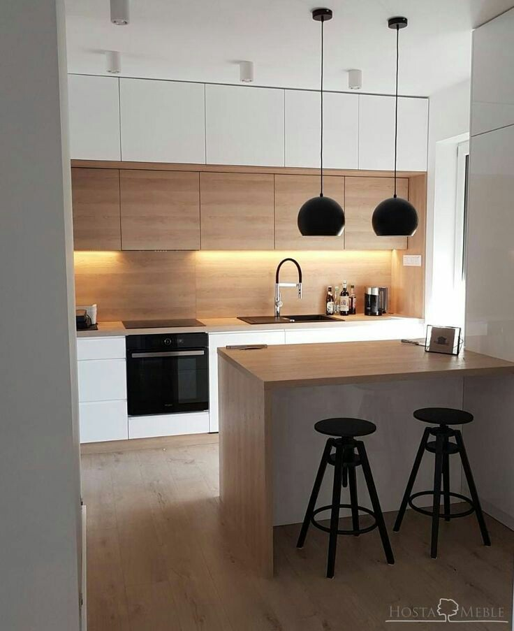 Aksen kayu memang sangat aman untuk dipadukan dengan warna putih. Kesan modern (yang tampak dari oven, pemilihan lampu gantung dan kursi) namun hangat (dari adanya material kayu) seketika datang dari dapur kecil ini