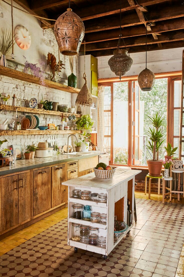 Dengan adanya rak panjang yang terbuat dari kayu pada bagian dinding dapur, anda bisa memilih island dapur mini dengan warna putih yang vintage. Lampu gantung berdesain rustic bisa menjadi hiasan yang cantik