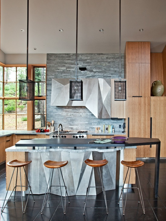 Salah satu cara untuk membuat dapur agar terlihat unik adalah memilih kitchen set dengan desain unik seperti aksen desain asimetris futuristik berwarna abu-abu yang menyatu dengan aksen kayu di sekitar dapur