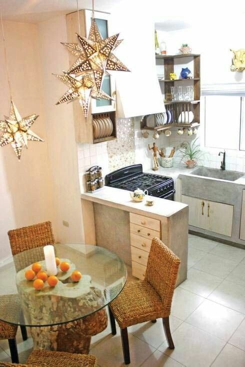 Buat dapur cantik minimalis anda yang mungil menjadi lebih menarik dengan memberikan lampu gantung yang berdesain seperti bintang di atas area makan, dan meja material kayu mentah yang dilapisi dengan kaca