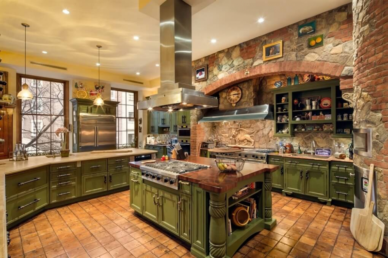 Kesan rustic atau pedesaan terlihat dari aksen batu terakota pada bagian dinding, namun kitchen set berwarna hijau ini memberikan kesan mewah dari desain pahatannya yang klasik