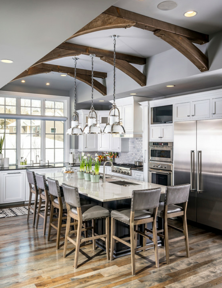 Dengan desain perpaduan rustic dan modern, anda dapat memilih balok kayu untuk aksen pada langit-langit, kitchen set berdesain sederhana berwarna putih dan meja makan yang terbuat dari batu granit putih