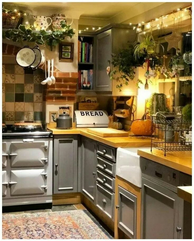 Dapur dengan tema rustic yang memiliki banyak ornamen dan hiasan seperti di bawah ini sepertinya sangat pas dipadukan dengan kitchen set minimalis warna abu-abu dan material kayu pada bagian countertop