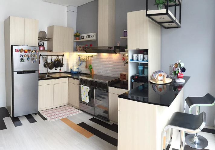 Perpaduan warna hitam putih yang sederhana namun chic terlihat dari desain kitchen set dengan bentuk huruf U ini. Terlebih lagi pada bagian atas terdapat rak dengan rangka besi yang bisa dipakai untuk tempat menaruh pot mini