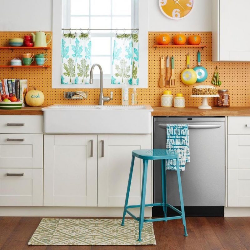 Dekorasi dengan warna-warna cerah dapat diberikan untuk anda yang mempunyai dapur dengan dominasi warna putih. Seperti peralatan makan anda yang berwarna hijau, biru, jam dinding dengan warna senada, juga tirai jendela bercorak bunga untuk pemanis