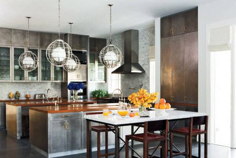 Aksen material konkrit yang terlihat dari kitchen set dapur bisa berpadu sempurna dengan aksen kayu yang ada pada countertop. Untuk lebih menambahkan daya tarik, empat lampu gantung berbentuk rangka bundar bisa menjadi alternatif
