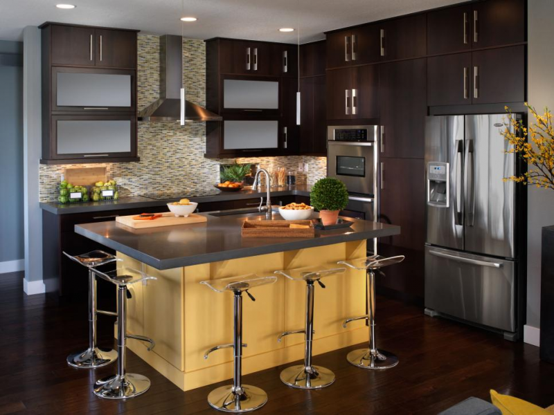 Dengan dominasi aksen kayu berwarna gelap pada area dapur anda, berikan sedikit sentuhan warna seperti kuning yang bisa anda aplikasikan pada perabotan meja dapur. Dengan adanya backsplash ini, dapur jadi nampak lebih kohesif