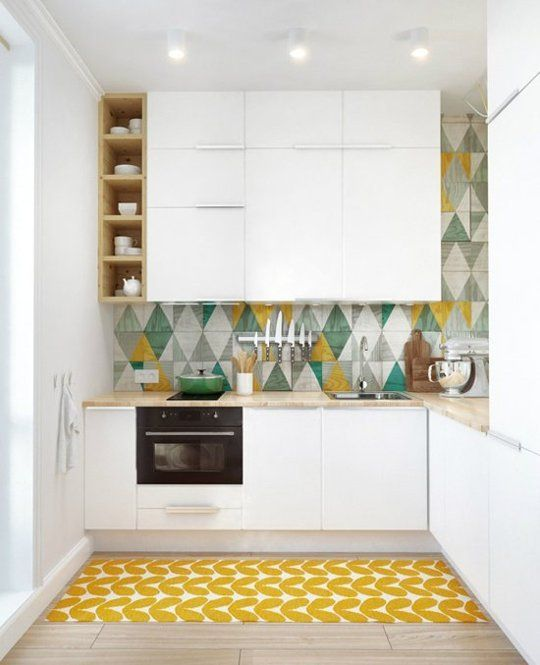 Dapur kecil yang didominasi warna putih lebih mudah untuk dikombinasikan dengan backsplash warna lain yang lebih cerah contohnya kuning. Anda bisa memberikan wallpaper dengan desain segitiga berwarna-warni atau karpet bercorak hati dengan warna cerah