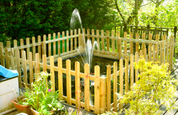 Taman kecil dengan kolam ikan dan teras kayu