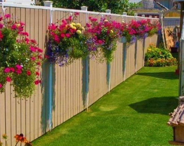 Taman kecil dengan pot bunga gantung di pagar