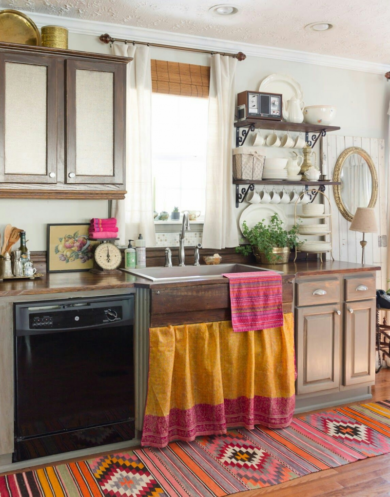 Perpaduan aksen kayu dan warna putih terlihat dari pemilihan kitchen set dan peralatan makan seperti cangkir. Namun untuk sedikit semburat warna lain, anda bisa menambahkan karpet dengan corak warna-warni