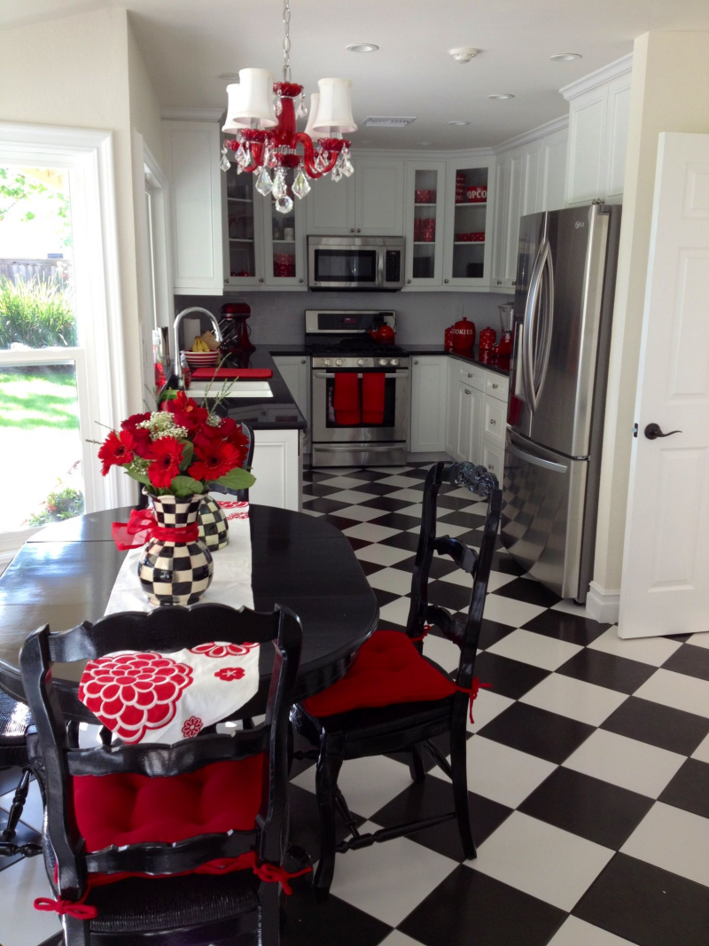Dominasi warna hitam dan putih terlihat jelas dari pemilihan kitchen set dan desain pada lantai. Namun hiasan dan peralatan dapur dengan warna merah yang berani membuat kesan yang tidak monoton