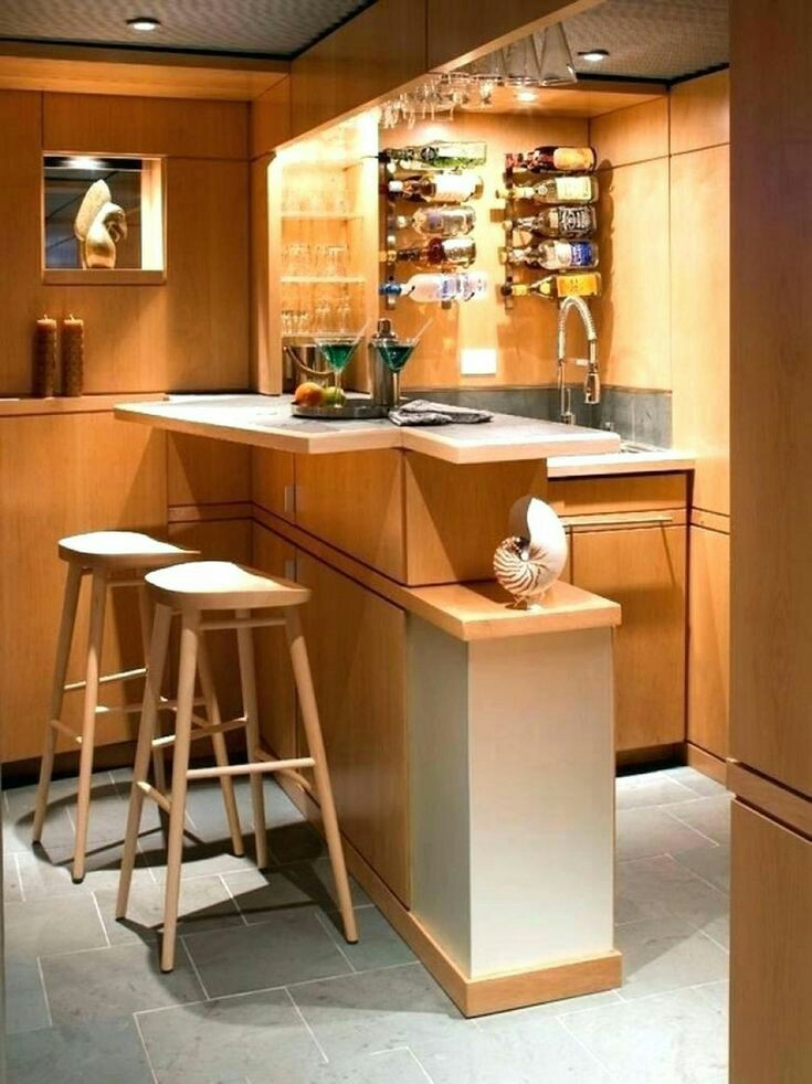 Pemanfaatan sudut rumah untuk dibuat menjadi mini bar dengan tampilan minimalis. Sentuhan kayu terlihat dari keseluruhan furnitur yang dipakai dengan meja asimetris dan rak botol yang menarik di dinding