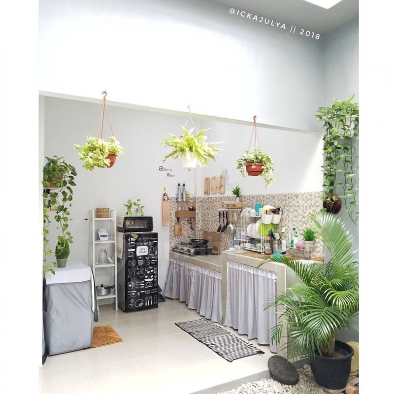 Kesan terbuka pada dapur terlihat dari adanya pencahayaan yang sempurna. Selain itu untuk membuat suasana dapur lebih segar, tambahkan beberapa tanaman gantung kecil di beberapa bagian dan satu tanaman berukuran besar