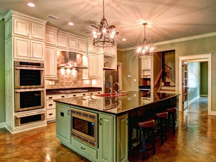 Warna hijau dari island dapur yang berada di tengah mengimbangi dominasi putih gading dari kitchen set di sekitarnya. Desain klasik ini tidak akan pernah terlihat membosankan untuk dapur anda