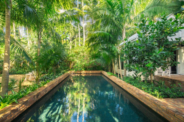 Kolam renang kecil dengan pohon rindang di dekatnya